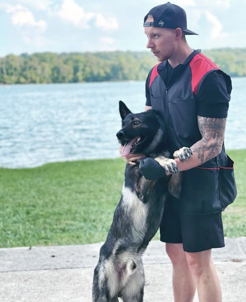 Trainer with a German Shepherd by the lake